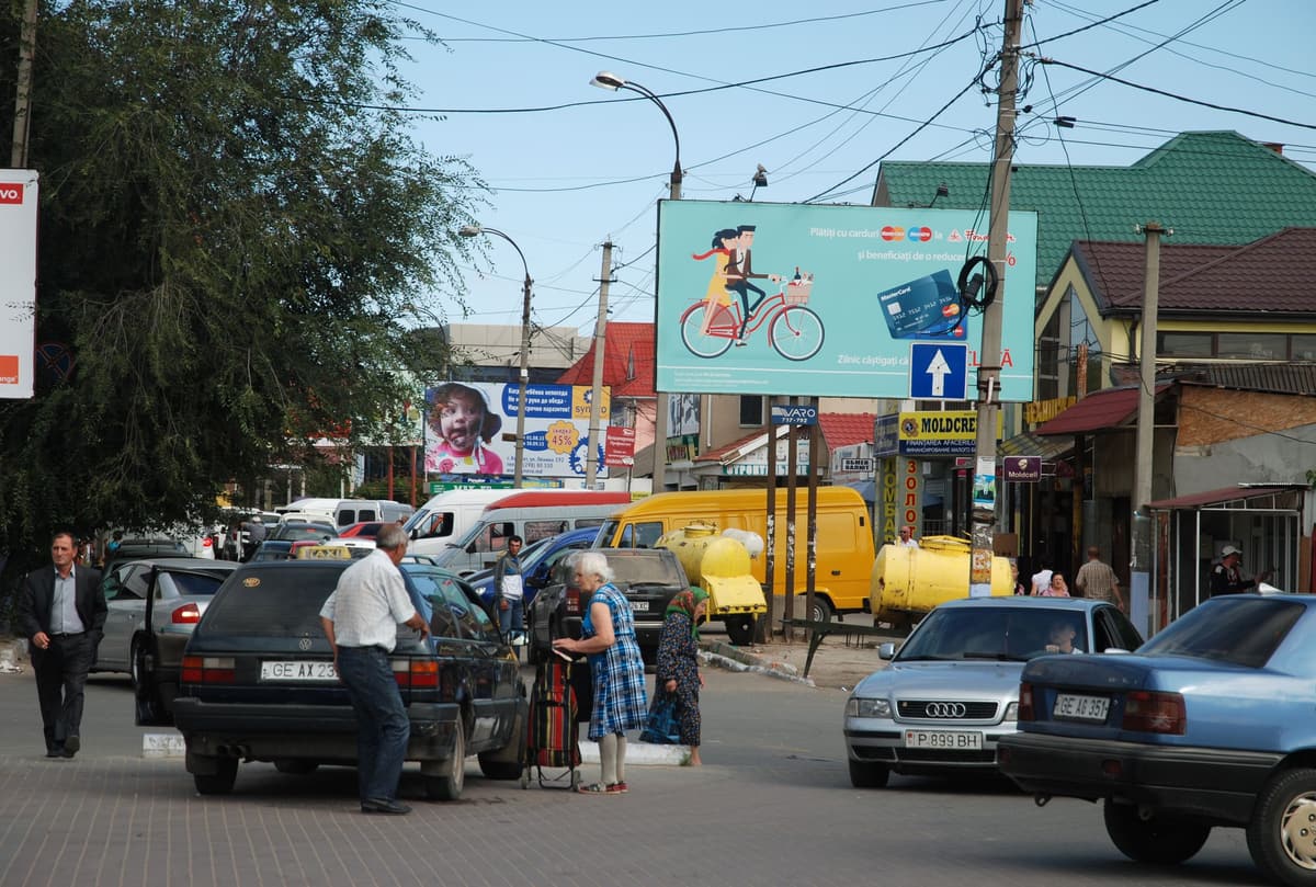 Shoppers and parked cars at the entrance to the market area in Comrat