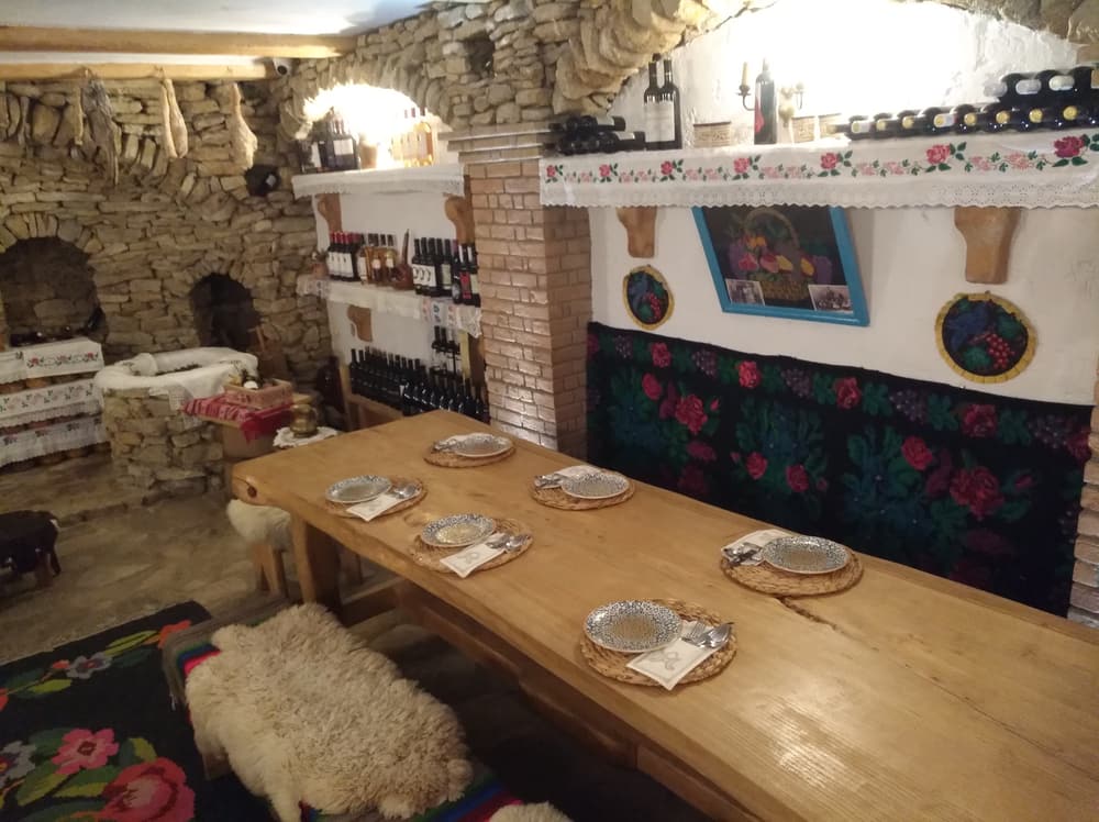 Ein langer Holztisch, gedeckt für ein Essen im Steinkeller von Gagauz Sofrası